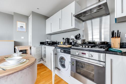 eine Küche mit Waschmaschine und Trockner in der Unterkunft Central Lux Penthouse with Balcony, Terrace & Prking in Bedford