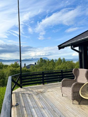a wooden deck with two chairs on top of it at High standard and beautiful view in Tennevika