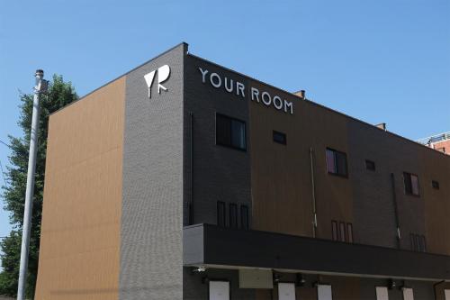 a building with a sign on the side of it at YOUR ROOM treehouse KUMAMOTO in Kumamoto