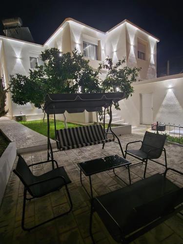 a group of chairs and a table in front of a building at Vila Oron in Vlorë