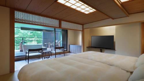 a bedroom with a bed and a flat screen tv at Tsuganoki in Nikko