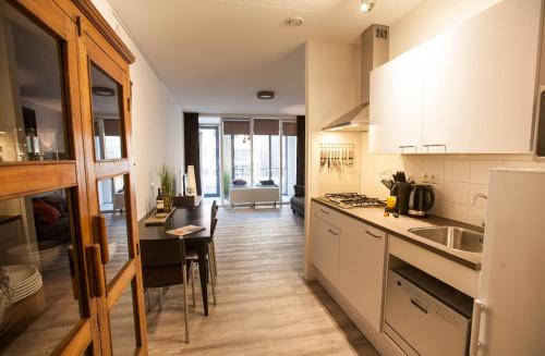 a kitchen with white cabinets and a table and a counter at Apartment 4G in Amersfoort