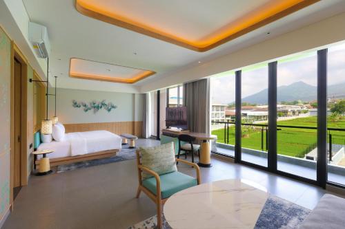 a bedroom with a bed and a large window at Hotel Santika Premiere Garut in Garut