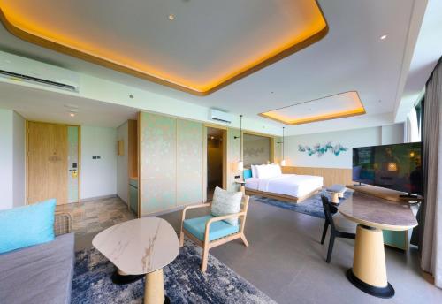 a living room with a couch and a bed and a television at Hotel Santika Premiere Garut in Garut