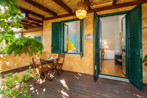 a patio with a table and chairs on a deck at Hotel Kalura in Cefalù