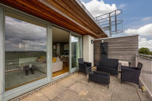 eine Terrasse mit Stühlen und einem Tisch auf einem Balkon in der Unterkunft Central Lux Penthouse with Balcony, Terrace & Prking in Bedford