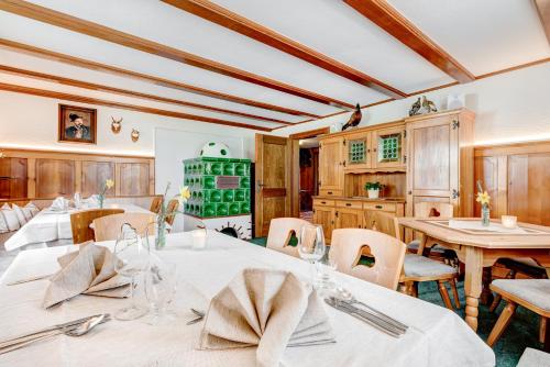 a dining room with white tables and chairs at Café Pension zum Jäger in Buchboden