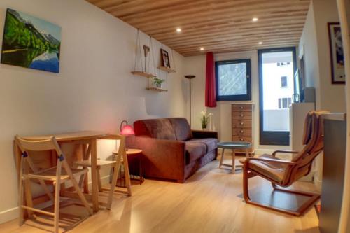 un salon avec un canapé, une table et des chaises dans l'établissement Modern Apt With View On The Aiguille Du Midi, à Chamonix-Mont-Blanc