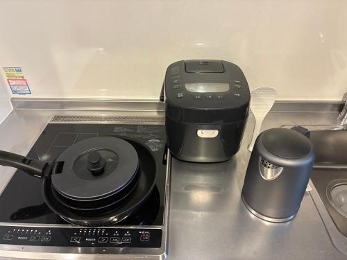 a kitchen counter with a printer and two trash cans at trive kanayama502 - 名駅へアクセス良好 最大5名宿泊可能 in Mutsunochō