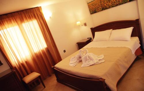 a bedroom with a bed with a towel on it at Mythos Beach Hotel Apartments in Maleme