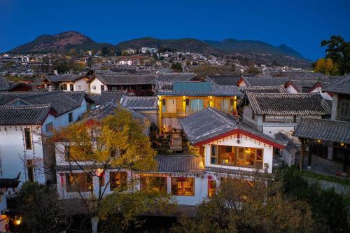 a group of houses in a city at night at Lijiang MuYa Chinese Courtyard Hotel with Water View in Lijiang