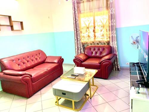 two red leather couches in a living room at Luxury apartment Yaoundé in Yaoundé