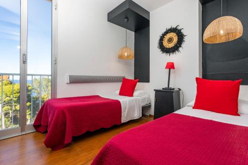two beds in a room with red and white at Hotel Kalura in Cefalù