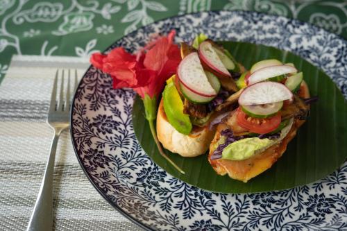 a plate of food with a sandwich with vegetables on it at HAKS Boutique B&B with Pool & Farm-to-Table Dining in Lahad Datu