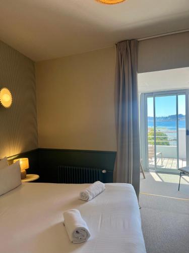 a hotel room with a bed with towels on it at Hôtel BelleVue in Bréhat
