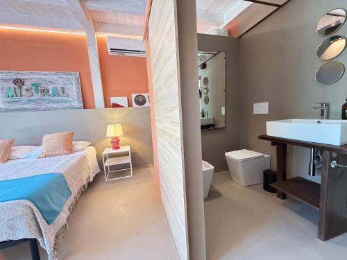 een slaapkamer met een bed en een badkamer met een wastafel bij Azalo Country House in Noto