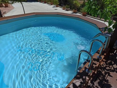 a swimming pool with blue water in a backyard at Casas Cuevas El Mirador con piscina y barbacoa in Fontanar