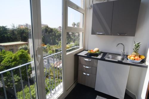 eine Küche mit einem Balkon mit einem Waschbecken und einem Fenster in der Unterkunft Napoli Milionaria B&B in Neapel