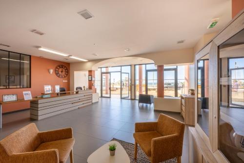 un hall de bureau avec des chaises et une réception dans l'établissement Résidence Prestige Odalys De La Plage, à Pornichet