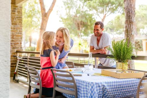 a woman and a girl sitting at a table at Golfo del Sole Hotel & Holiday Resort in Follonica