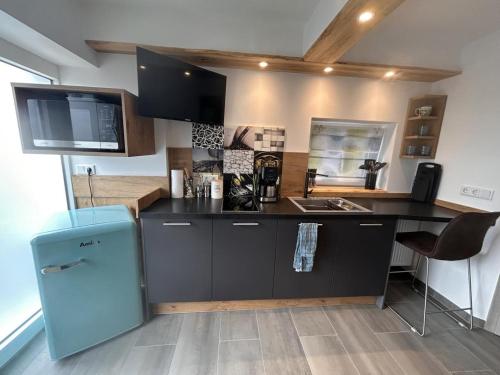 a kitchen with a black counter and a blue refrigerator at NEU! Apartment Engel in Weilburg