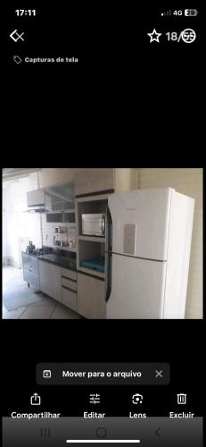 a picture of a kitchen with a white refrigerator at Chalé Ricmarques in Esteio