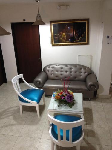 a living room with a couch and a table and chairs at Hotel Casa Pablo in Neiva