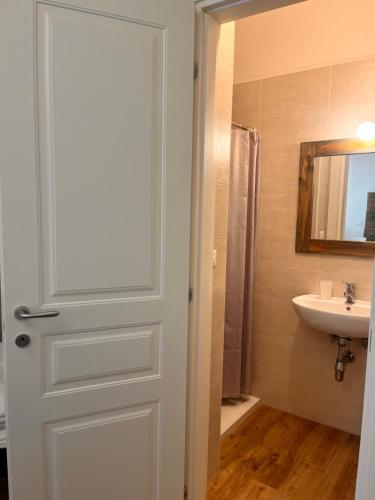 a bathroom with a white door and a sink at Il Nido tra le Mura Polignano in Polignano a Mare