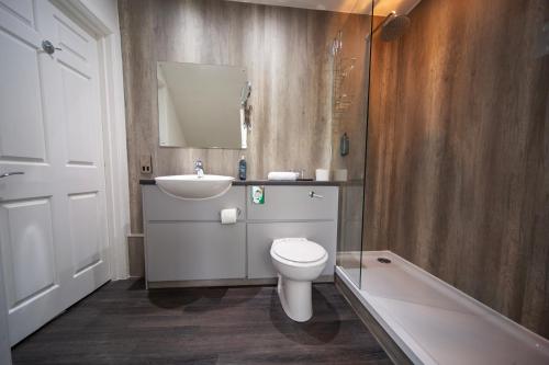 a bathroom with a toilet and a sink and a tub at Barony Castle Hotel in Peebles