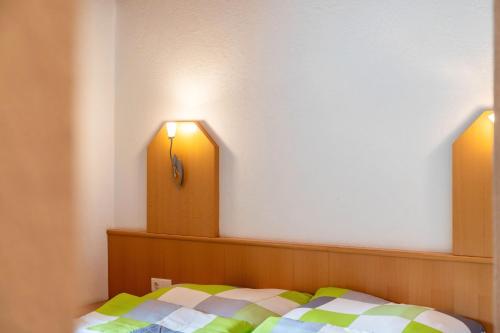 a bedroom with a bed and two lights on the wall at Gasthaus Mamoosen in Penning