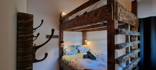 ein Schlafzimmer mit einem Etagenbett aus Holz in einem Zimmer in der Unterkunft Appart 3 pièces Cosy - idéal famille & sports Le Cairn De Samoëns in Samoëns