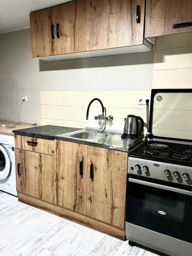 a kitchen with a sink and a stove at Hotel New Terrace in Tbilisi City