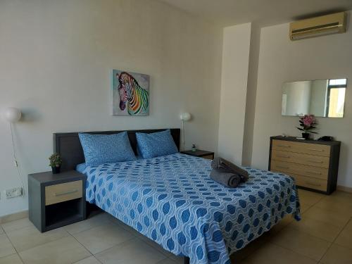 a bedroom with a bed with a blue comforter at Private Rooms in a Penthouse in Malta between Capital of Valletta and St Julians nightlife in Msida