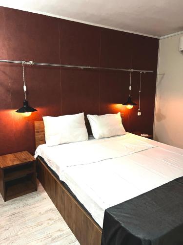 a large bed with two white pillows and two lights at Hotel New Terrace in Tbilisi City