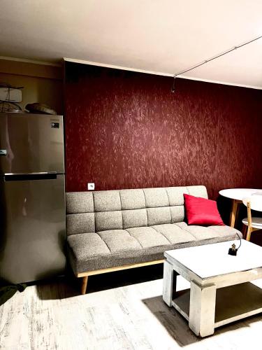 a living room with a couch and a red wall at Hotel New Terrace in Tbilisi City