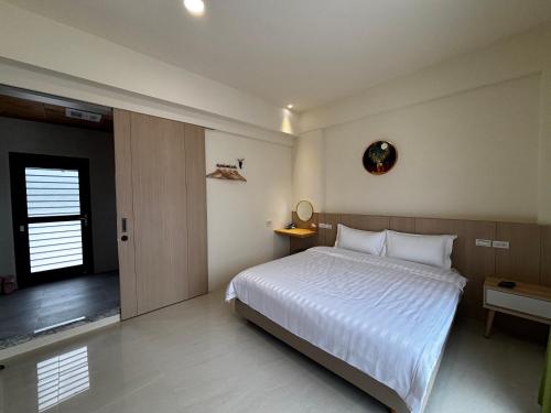 a bedroom with a large white bed and a window at Qianlian Xiaojing & Xiutian Xiaomind in Longtian