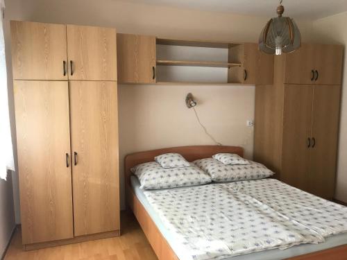 a bedroom with a bed with wooden cabinets at Erika-Vendégház in Poroszló