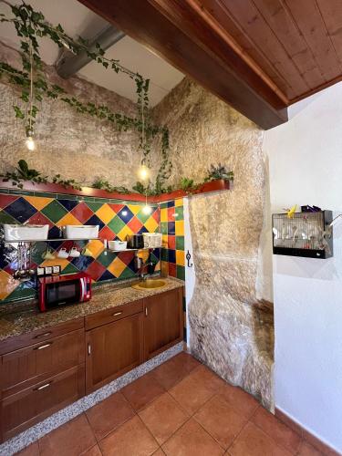 a kitchen with a counter with a colorful tile wall at monmossen bocairent in Bocairent