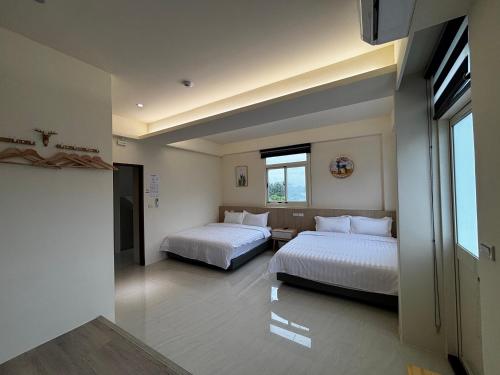 a bedroom with two beds and a window at Qianlian Xiaojing & Xiutian Xiaomind in Longtian