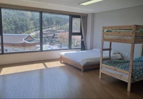 a bedroom with a bunk bed and a large window at Sancheong Korean Medicine Family Hotel in Sancheong