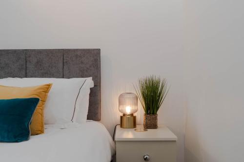 a bedroom with a bed and a lamp on a nightstand at Hale Lodge in London