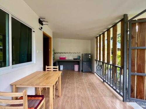 a dining room with a table and a kitchen at CHALOK LUM - LOVE HOME, near of MUYA THAI and the CHALOK LUM BEACH in Chaloklum
