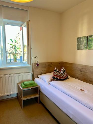 a bedroom with two beds and a window at Athecada Frühstückspension in Birkfeld