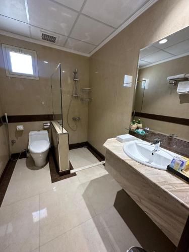 a bathroom with a toilet and a sink and a mirror at شقق جوين للوحدات السكنية المفروشة- اقتصادي in Jeddah