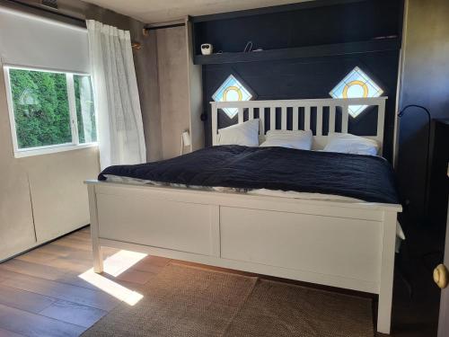 a bedroom with a large white bed with a blue headboard at Villavagn in Gärds Köpinge