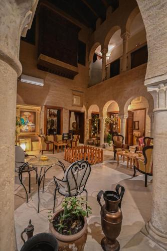 a lobby with chairs and tables in a building at Palais Harran in Kairouan