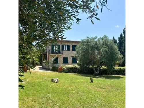 a house with a grass yard in front of it at B&B Villa Miramì in Saturnia