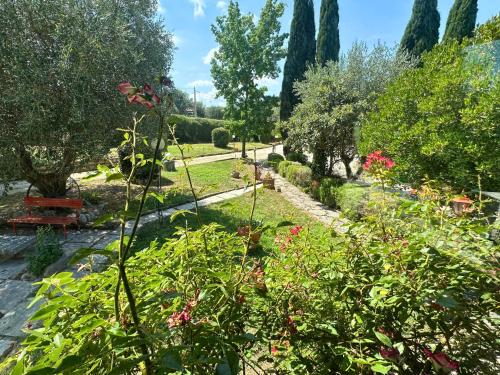 a garden with flowers and trees on a sunny day at B&B Villa Miramì in Saturnia