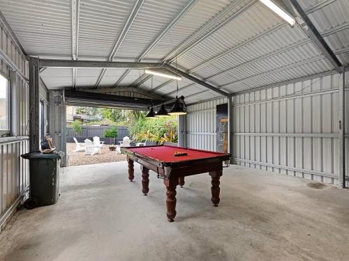 a garage with a pool table in it at Pantai Indah Cottage in Hervey Bay