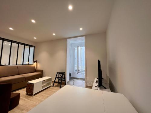 un salon avec un canapé et une télévision dans l'établissement Appartement lumineux 2 pièces, cœur de Saint-Jean-de-Luz, proche plage et commerces, avec WIFI - FR-1-239-1002, à Saint-Jean-de-Luz